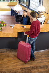 Man With Luggage At Hotel Reception