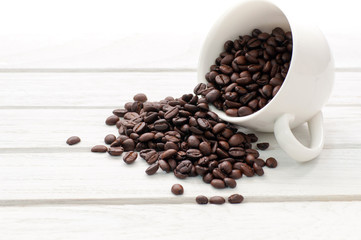 coffee beans and cup on white wood