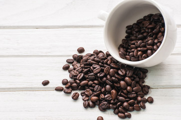 Fototapeta na wymiar coffee beans and cup on white wood