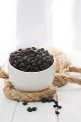 coffee beans and cup on white wood