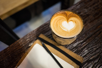 Heart shape latte art hot coffee with leather cover notebook