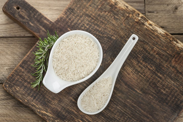 Basmati und Jasminreis auf rustikalem Eichenholzbrett in chinesischer Schale