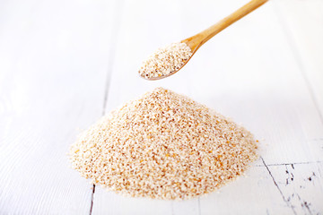 Sesame seeds with a wooden spoon