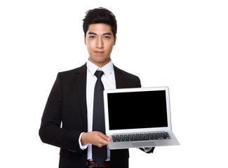 Asian Businessman showing the blank screen of laptop computer