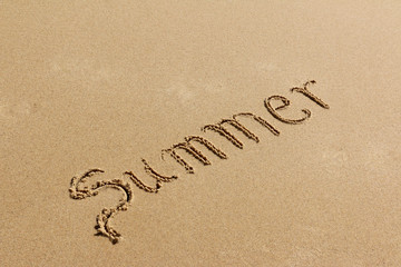 Summer - text written by hand on sand on a beach