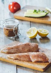 Fresh meat on wooden board with spice, tomato and lemon on table   © Micko1986