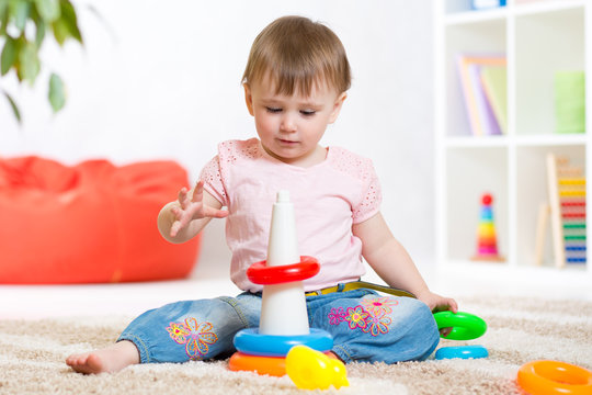 Toddler playing with wooden blocks at home