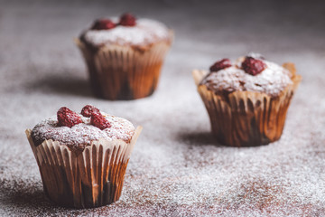 Muffins on a wooden table covered with sugar. 
