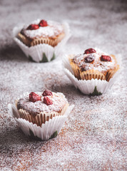 Muffins on a wooden table covered with sugar. 
