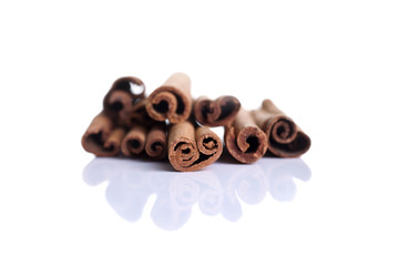 Cinnamon sticks shot front on on a white background with reflection
