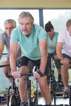 Group of seniors using spinning bikes