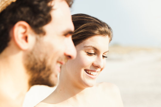 Portrait of a beautiful couple on the beach at sunset. Close-up while smiling and joking after a day of relaxation and fun in the summer break