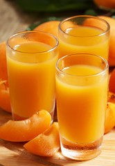 Fresh apricot juice and apricots with mint on wooden board, sele