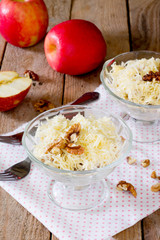 Salad with chicken, apples, walnuts and cheese on a wooden background