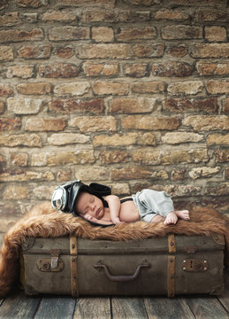 Little pilot baby sleeping on the luggage