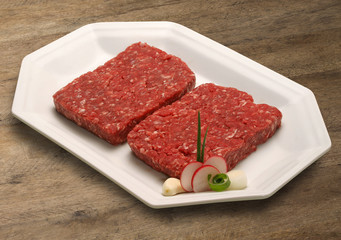 Raw meat selection on wooden cutting board with knife