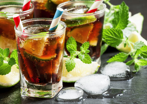 Cuba Libre with lime, mint and ice in a glass, selective focus
