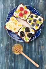 Sweet sandwich with berries, fruit, cream cheese, chia seeds and honey. A healthy breakfast. Top view