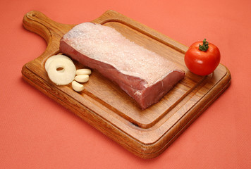 Raw meat selection on wooden cutting board with knife