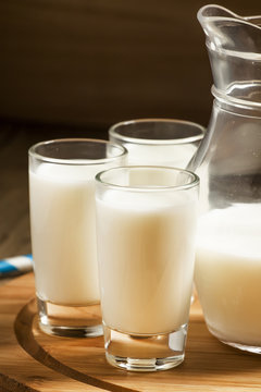 Jug of milk on old wooden table in rustic style, selective focus