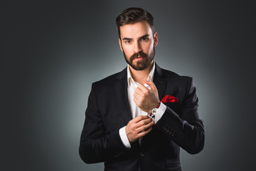 Man's style. Elegant young man getting ready. Dressing suit, shirt and cuffs
