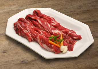 Raw meat selection on wooden cutting board with knife