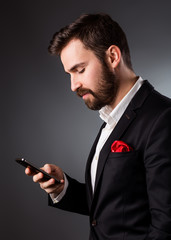 Young handsome businessman in suit holding a phone
