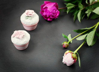 PEONY flowers and little perfumery boxes over slate