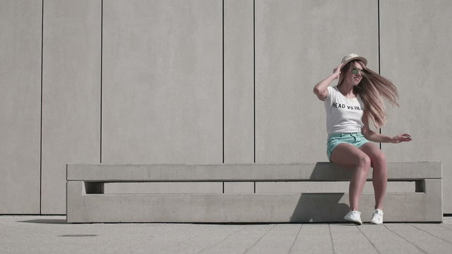 Energetic Young Woman in Fitness Outfit, Exercising Using Jumping Rope Against White Wall Background on a Sunny Climate.