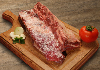 Raw meat selection on wooden cutting board with knife