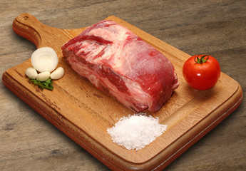 Raw meat selection on wooden cutting board with knife