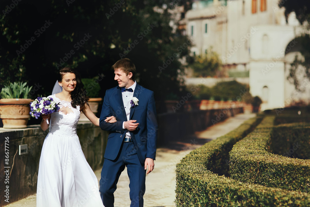 Wall mural romantic young stylish  italian newlyweds  couple walking spring