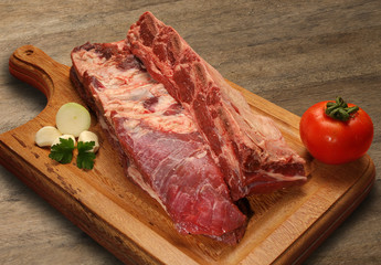 Raw meat selection on wooden cutting board with knife