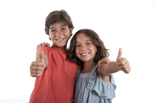 Ni&ntilde;o y ni&ntilde;a sonriendo y levantando el pulgar