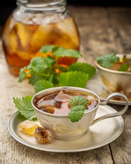 Cool summer tea with mint and ice cubes in a silver cup