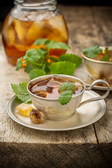 Cool summer tea with mint and ice cubes in a silver cup