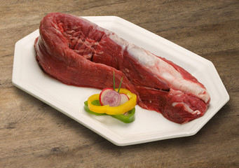 Raw meat selection on wooden cutting board with knife