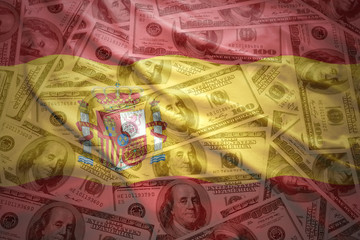 colorful waving spanish flag on a american dollar money background