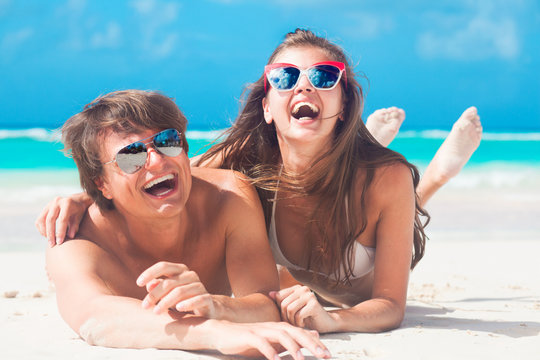 Closeup of happy young caucasian couple in sunglasses smiling at