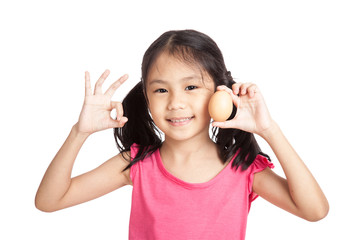 Little asian girl show OK with an egg in hand