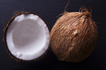 Whole and halved coconuts shot from above on a white backgroundfrom above