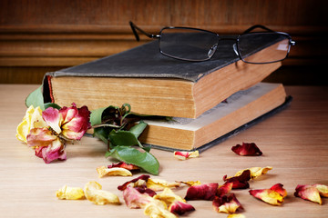 Dry rose and the old book on a table