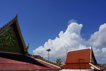 Fototapeta na wymiar Белые облака над крышами буддийского монастыря