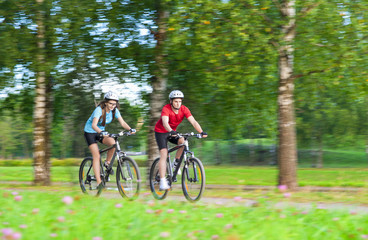 Two Bicycle Riders Having Time Together Outdoors in Summer Fores