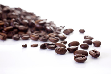 Coffee beans scattered shot on a white background at an angle