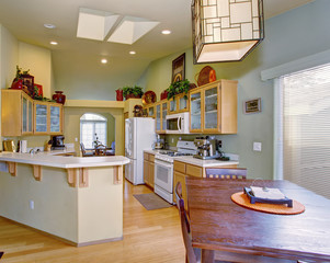 Modernized kitchen with light green walls and hardwood floor.