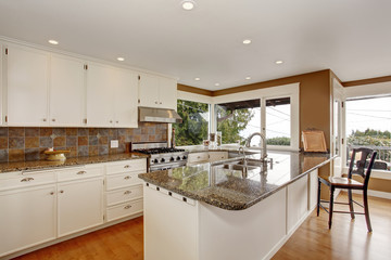Brilliant kitchen with white accents, and marble counters.
