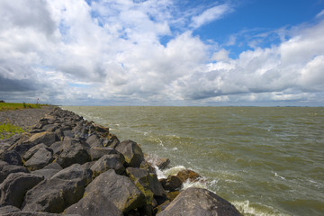 Fototapeta na wymiar Basalt rocks protecting a dike along the coast of a sea