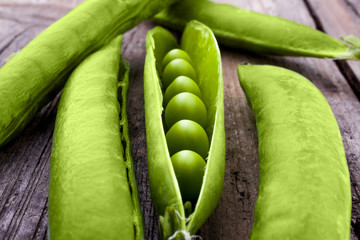 Peas in a pod shot at an angle from above on a wooden background landscape