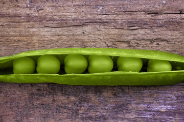 Peas in a pod shot from above on a wooden background